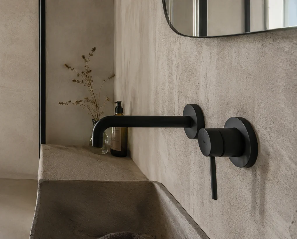 Grifería negra mate sobre pared gris, tendencia para baños y cocinas en Tarragona