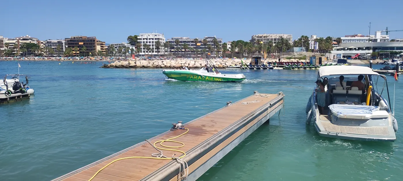 Zona de playa y puerto de Salou en temporada alta con apartamentos al fondo