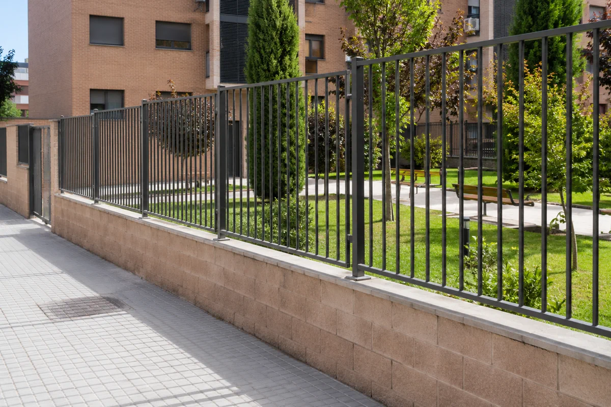 Valla metálica o cerramiento perimetral instalado en una zona exterior de comunidad de vecinos