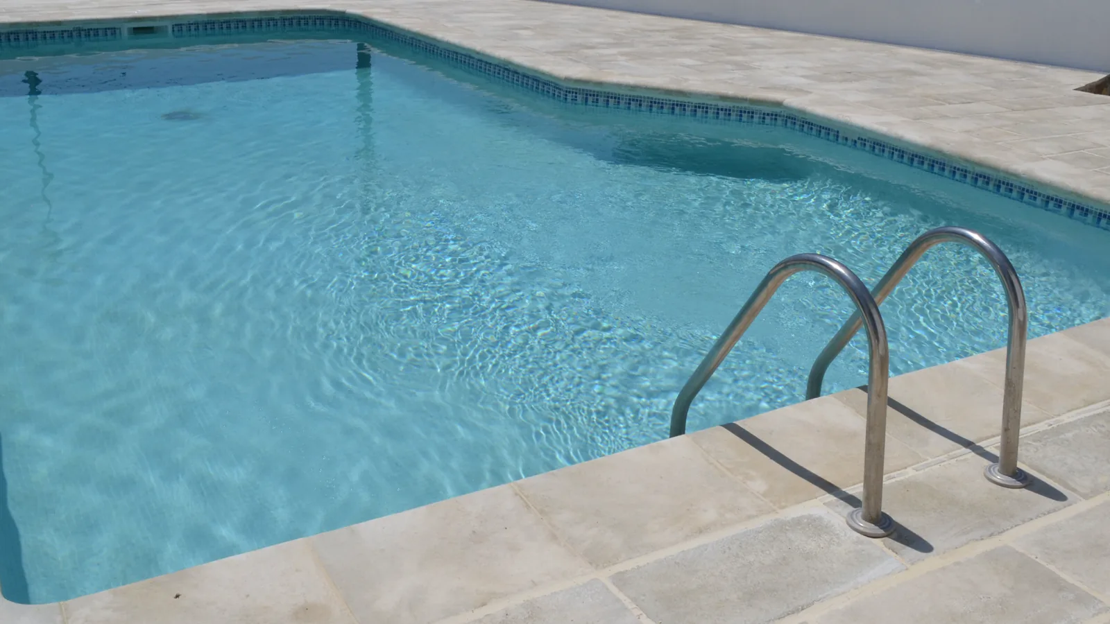 Piscina comunitaria con suelo exterior renovado en una comunidad de propietarios