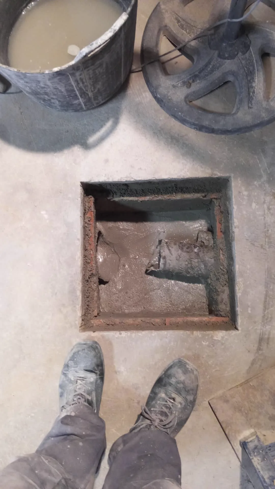 Interior deteriorado de una arqueta con sedimentos y marco oxidado antes de la reparación en Reus