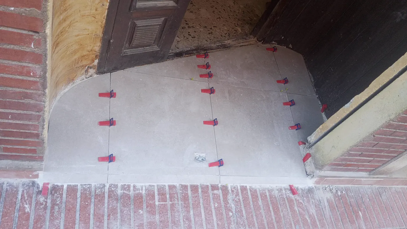 Baldosas colocadas con calzas de nivelación en la entrada del local en Tarragona