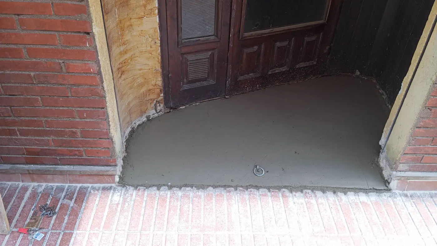 Entrada del local con mortero autonivelante antes de instalar las baldosas en Tarragona